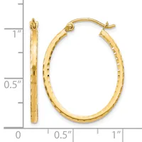 Gold oval hoop earrings with textured surface shown next to a measurement ruler indicating approximately one inch in length.