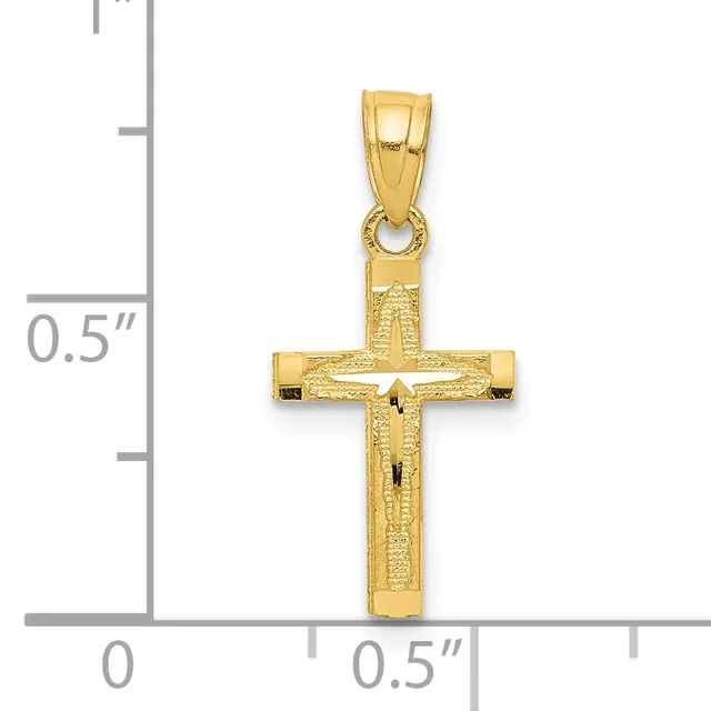 A gold crucifix pendant with textured surface and small crossbeam details, shown next to a ruler indicating approximately one inch in height.
