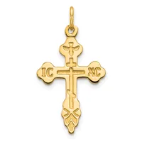Gold cross pendant with ornate flared ends and decorative flourishes at the bottom, featuring initials on the horizontal arms and a loop at the top for hanging.