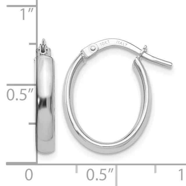 A pair of polished silver-colored oval hoop earrings with a hinged clasp, shown next to a measurement scale indicating approximately one inch in height and half an inch in width.