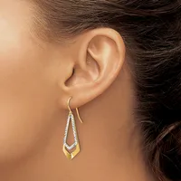 A person wearing gold and diamond teardrop-shaped earrings with a curved hook post, shown from the side view of their ear and neck.