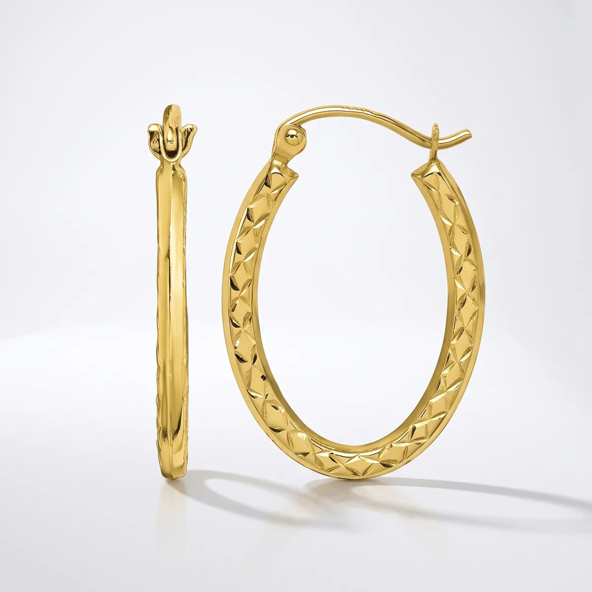 A pair of gold hoop earrings with textured quilted surface, shown from front and side view against a white background.