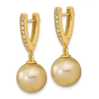 Pair of gold huggie earrings with diamond accents on the upper curved section and dangling golden pearl drops.