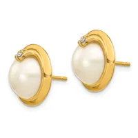A pair of gold stud earrings featuring oval white pearls set in polished gold bezels with small diamond accents at the top.