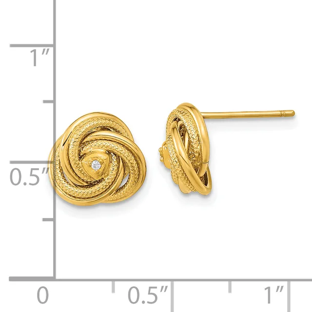 A pair of gold knot stud earrings with a textured finish and small diamond accents, shown next to a ruler for scale.