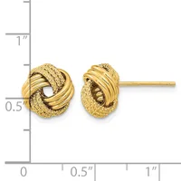 A pair of gold twisted knot stud earrings with textured and polished surfaces, shown at actual size next to a measurement ruler.