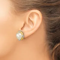 A woman wearing a two-tone earring with a white pearl center surrounded by small diamonds in a gold and silver setting, shown from the side view of her ear.