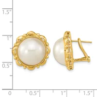Pair of gold-toned clip earrings with white pearl centers surrounded by ornate scalloped bezels, shown next to a measurement ruler.