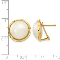 Pair of round white pearl stud earrings with gold-tone settings and omega backs, displayed next to a measurement ruler.