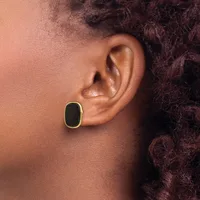 A person wearing a gold-rimmed oval earring with a black center stone in their pierced earlobe, shown in profile.