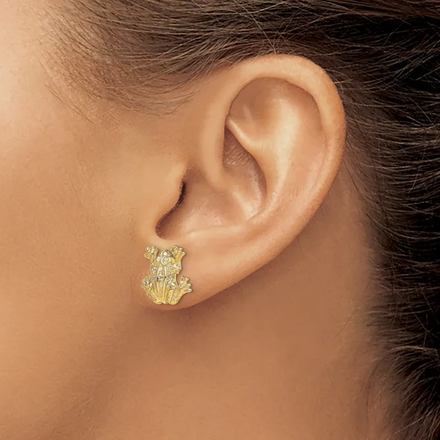A close-up of a person's ear wearing a gold textured stud earring with an organic, layered design.