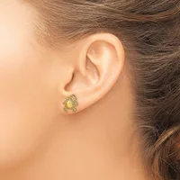 A gold-toned crab-shaped earring with a pale yellow stone center on a wearer's ear lobe.