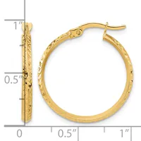 A pair of gold hoop earrings with textured surface finish, displayed next to a measurement scale showing approximately one inch in length.