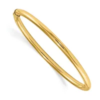 A polished gold-toned bangle bracelet with a hinged clasp, displayed at an angle against a white background.