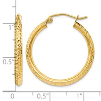 Gold hoop earrings with a textured diamond-cut surface, measuring approximately one inch in diameter, displayed next to a measurement scale.