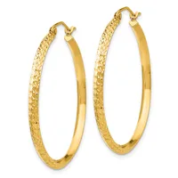 A pair of gold hoop earrings with textured outer surfaces and polished inner surfaces, shown against a white background.