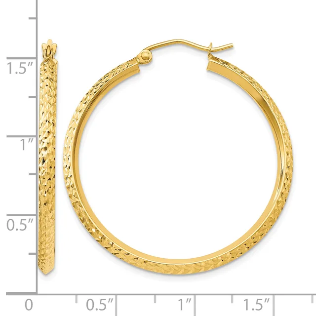 Gold hoop earrings with textured surface shown next to a ruler measuring approximately 1.5 inches in diameter.