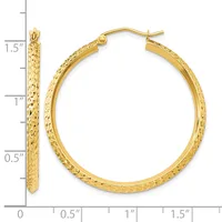 Gold hoop earrings with textured surface shown next to a ruler measuring approximately 1.5 inches in diameter.