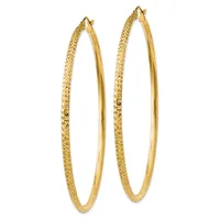 A pair of large gold hoop earrings with textured outer surfaces and polished inner surfaces, shown against a white background.