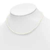 A strand of cream-colored round pearls displayed on a white mannequin bust, forming a classic single-strand necklace.