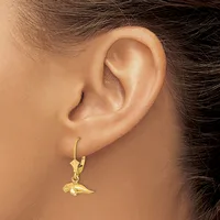 A gold lever-back earring with a small bird charm hangs from a woman's earlobe.