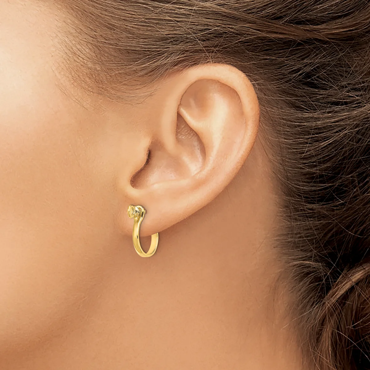 A person wearing a gold hoop earring with a small diamond or crystal stone stud, shown from the side profile of their ear and neck.