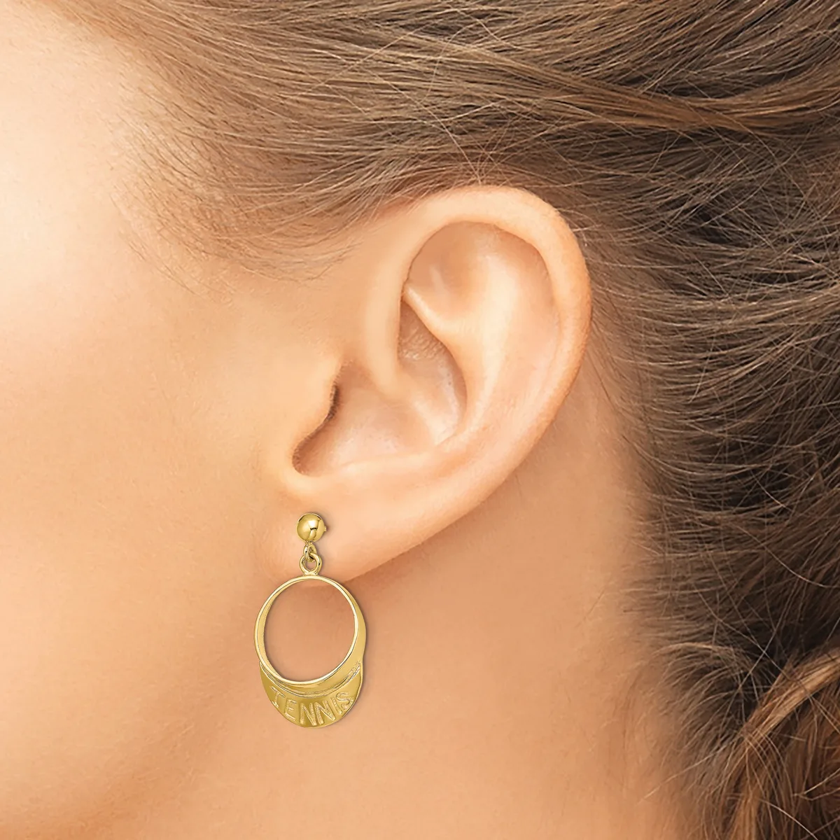 A gold-toned circular dangle earring with a smaller open circle at the top and a larger open circle below, worn on a person's earlobe.