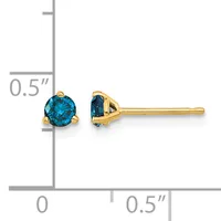 A pair of gold stud earrings with round blue gemstones set in four-prong mountings, displayed next to a ruler showing approximately 0.5 inches in height.