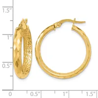 A pair of gold hoop earrings with textured and polished surfaces, shown next to a measurement scale indicating approximately one inch in diameter.