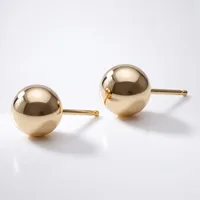A pair of polished gold ball stud earrings with thin posts, displayed on a white surface.