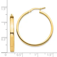 Gold-toned hoop earrings with a polished finish and hinged closure, displayed next to a measurement scale showing approximately 1.5 inches in diameter.