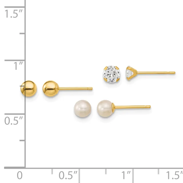 Three pairs of gold stud earrings displayed on a ruler: polished gold balls, a cubic zirconia stone, and cream-colored pearl studs.