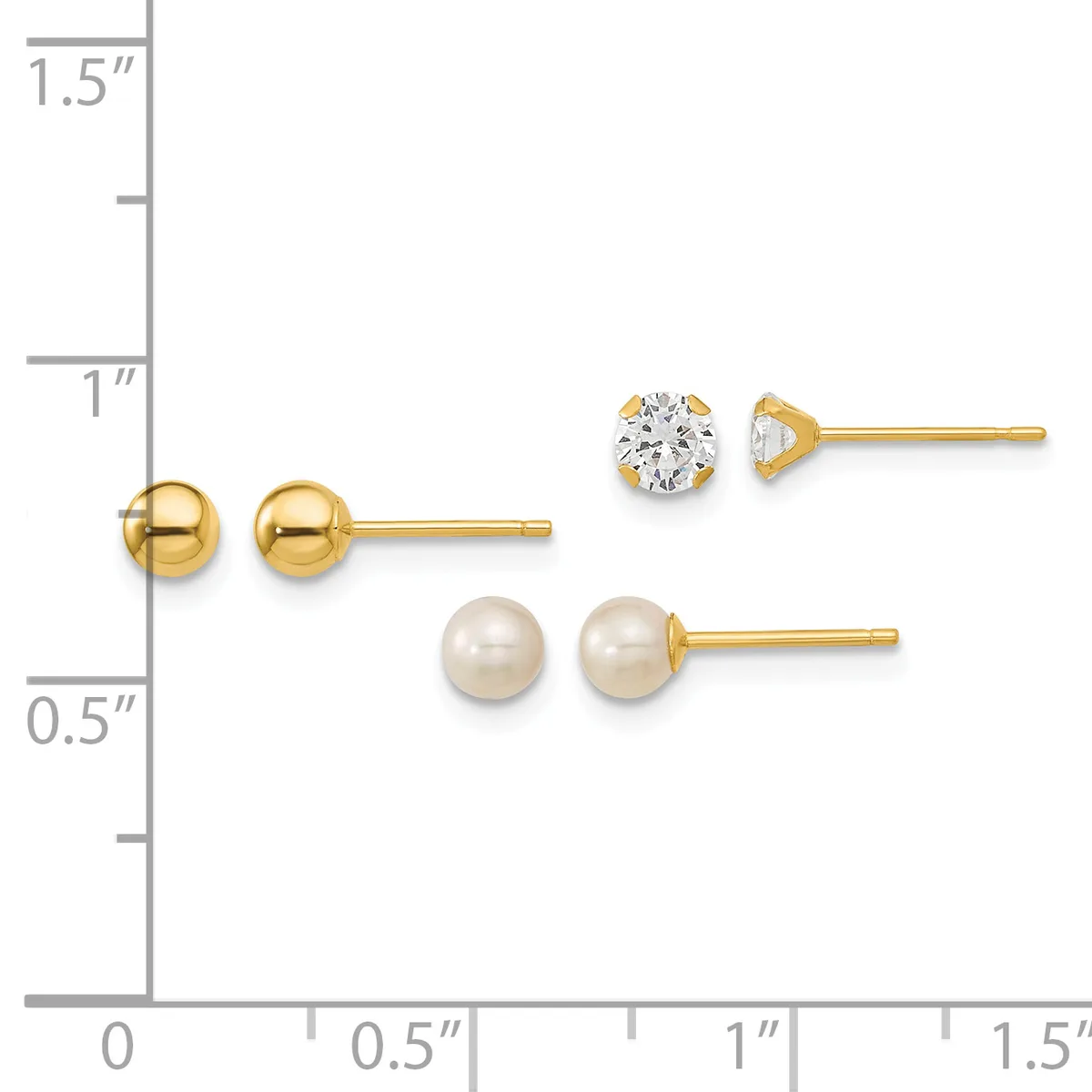 Three pairs of gold stud earrings displayed on a ruler: polished gold balls, a cubic zirconia stone, and cream-colored pearl studs.
