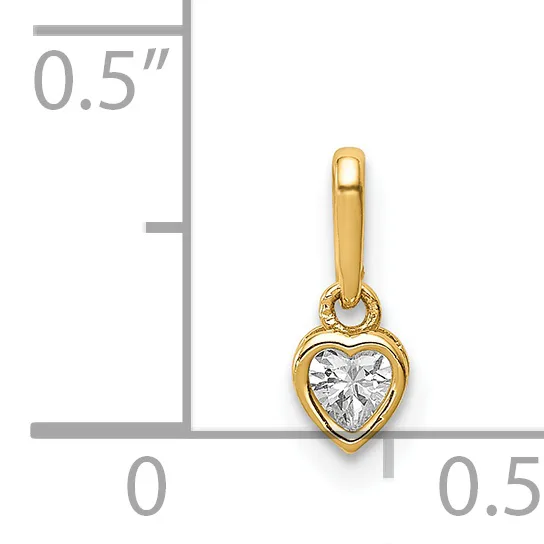 Gold heart-shaped pendant with bezel-set clear cubic zirconia stone and bail, displayed next to a ruler showing approximately half-inch length.