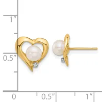 A pair of gold heart-shaped stud earrings, each featuring a cultured pearl in the center with a small diamond accent, shown front and side view next to a measurement scale.