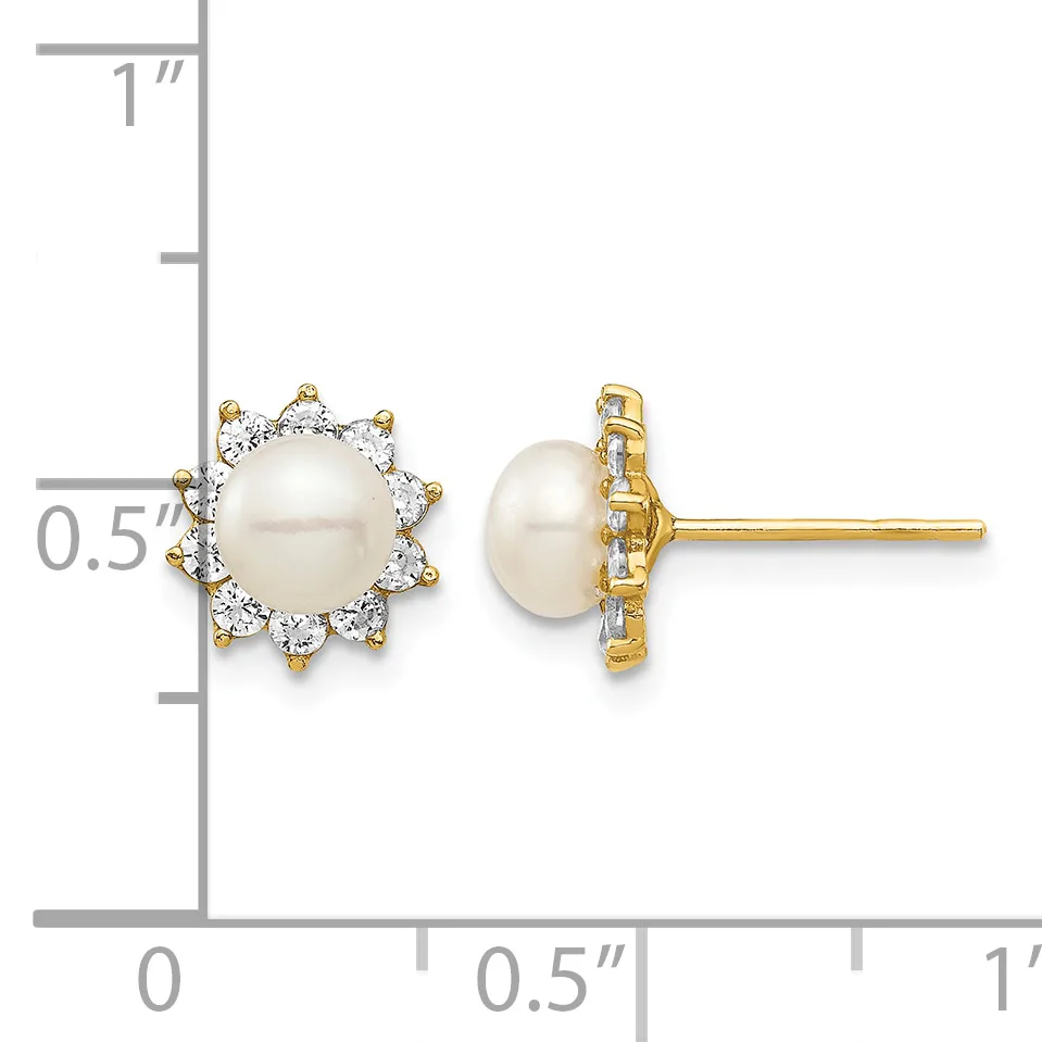 A pair of stud earrings featuring round white pearls surrounded by diamond halos in gold settings, displayed against a measurement scale.