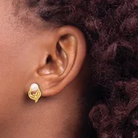 A close-up view of a person's ear wearing a gold-toned stud earring with a white pearl set in a curved, looped design.