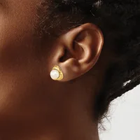 A person wearing a gold-toned stud earring with a white pearl center, shown from the side profile against their ear.