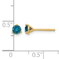 Pair of gold stud earrings with round blue gemstones in prong settings, shown against a measurement scale indicating approximately half-inch size.