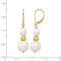 Two gold lever-back earrings with white pearl drops suspended from textured gold beads, displayed against a measurement scale showing approximately two inches in length.