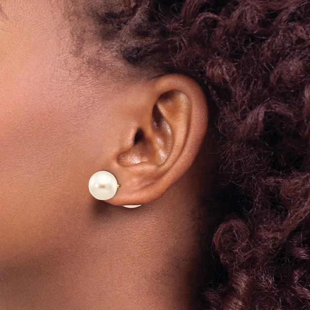 A person wearing a white pearl stud earring is shown in profile, with their head tilted slightly, displaying their ear and dark curled hair.