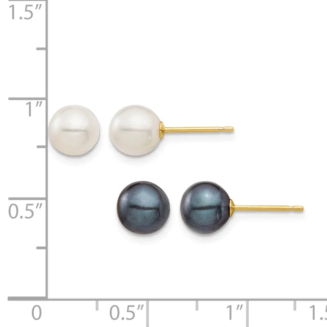 Two pairs of pearl stud earrings displayed on a ruler showing measurements: white pearls at approximately one inch and black pearls at approximately half inch, each pair with gold posts.