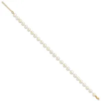 A gold chain bracelet with evenly spaced round white pearl beads throughout its length, displayed diagonally on a white background.