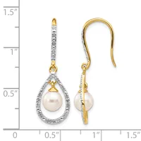 Pair of gold and diamond teardrop earrings with pearl centers, suspended from curved ear wires, displayed against a measurement scale.