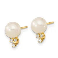 Pair of gold stud earrings with cream-colored pearl tops and diamond accents beneath each pearl.