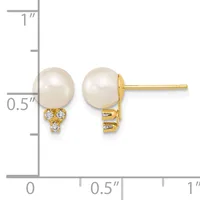 Pair of gold stud earrings with white pearl tops and three small diamond accents below each pearl, displayed against a measurement ruler showing approximately half inch height.