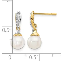 Pair of gold drop earrings with white pearl drops and diamond-set tops, shown next to a ruler measuring approximately one inch in length.