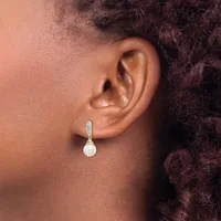 A person wearing a drop earring with a white pearl and diamond or crystal accent on a metal post, shown from the side profile.