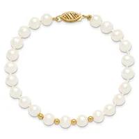 White pearl bracelet with gold-tone spacer beads and an ornate gold-tone clasp, displayed on a white background.