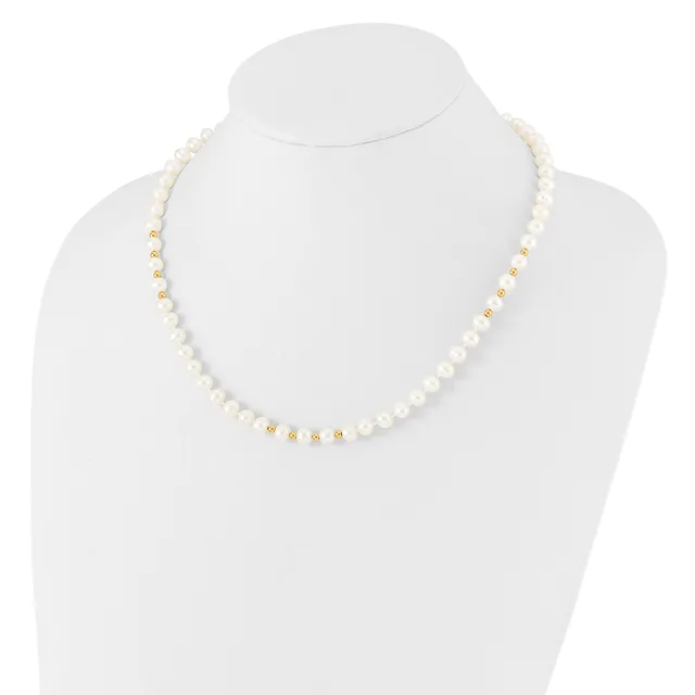A white pearl beaded necklace with gold-tone spacer beads displayed on a white mannequin bust.